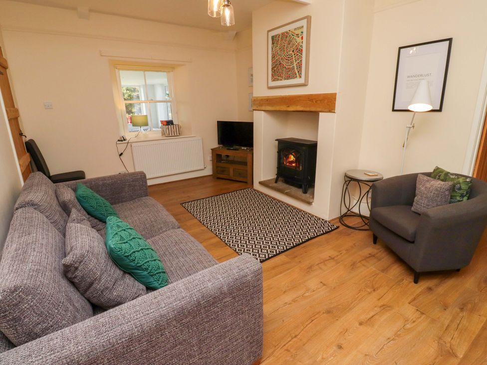 A living room with a sofa and fireplace at Barleycorn Cottage in Belford