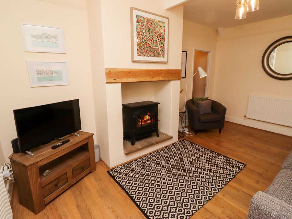 A living room with a fireplace and television at Barleycorn Cottage in Belford