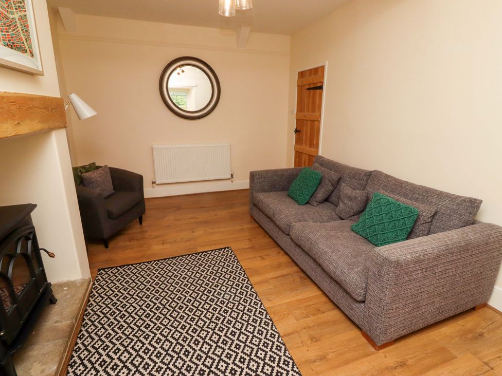 A living room with a sofa and armchair at Barleycorn Cottage in Belford