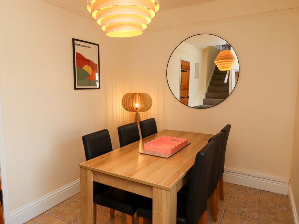 A dining room with a table and chairs at Barleycorn Cottage in Belford