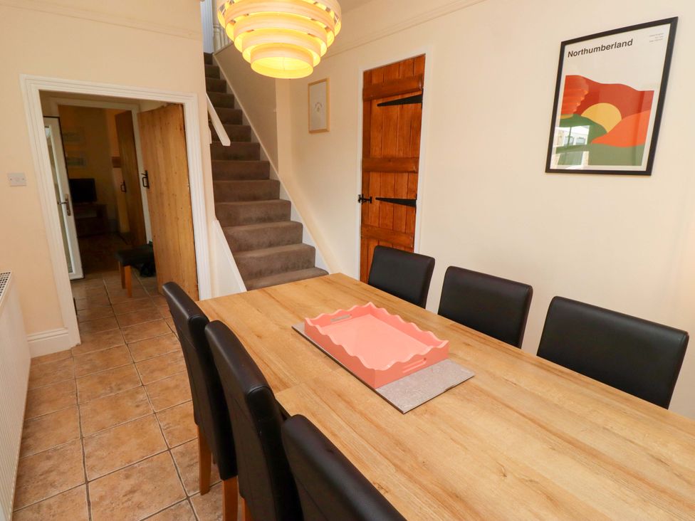 A dining room with a table and chairs at Barleycorn Cottage in Belford