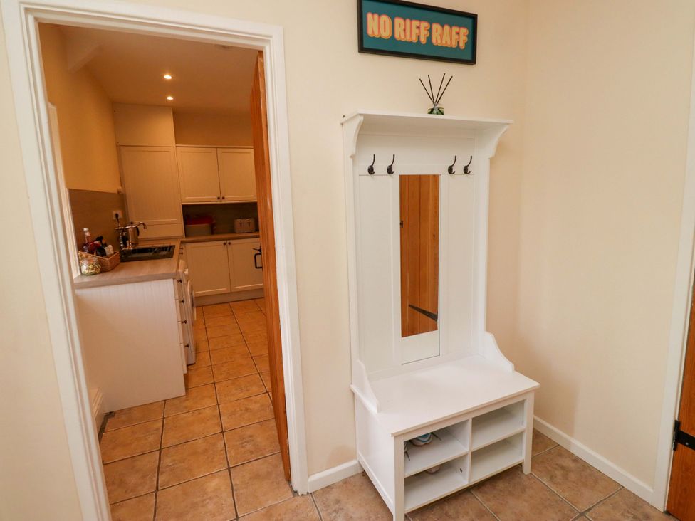 A hallway with a bench and hooks at Barleycorn Cottage in Belford