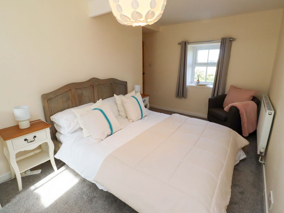 A bedroom with a bed and nightstand at Barleycorn Cottage in Belford