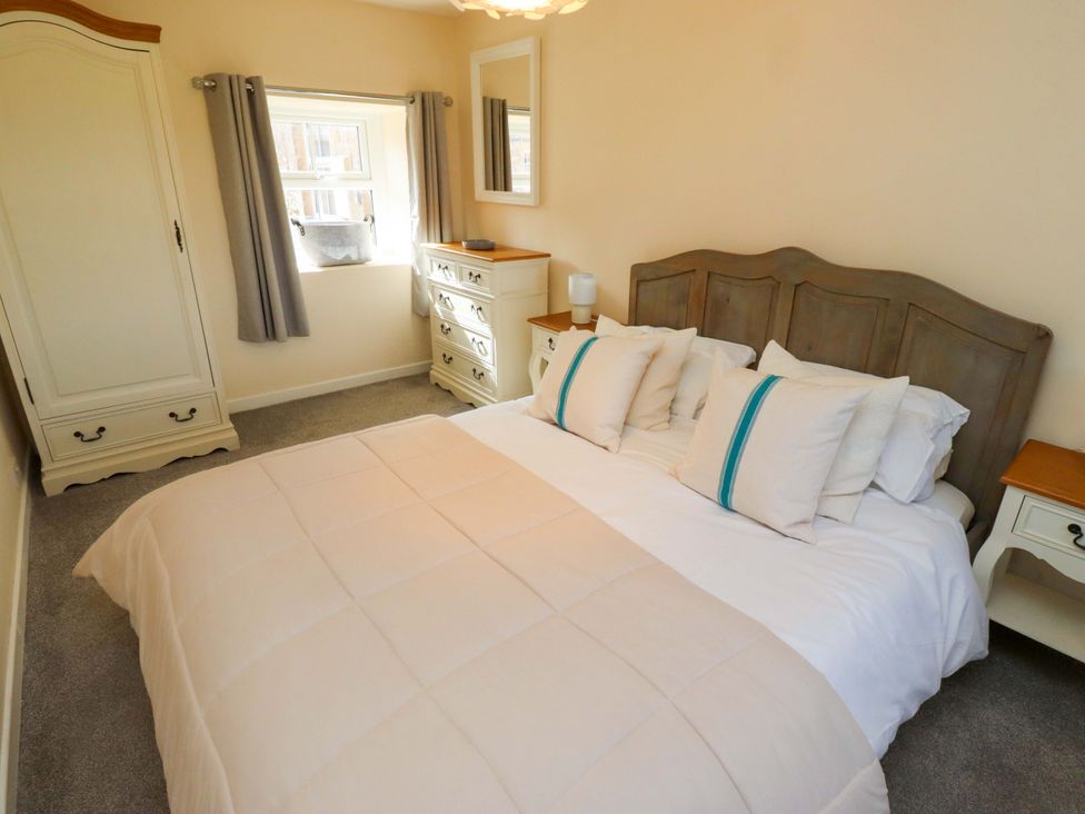 A bedroom with a bed and wardrobe at Barleycorn Cottage in Belford