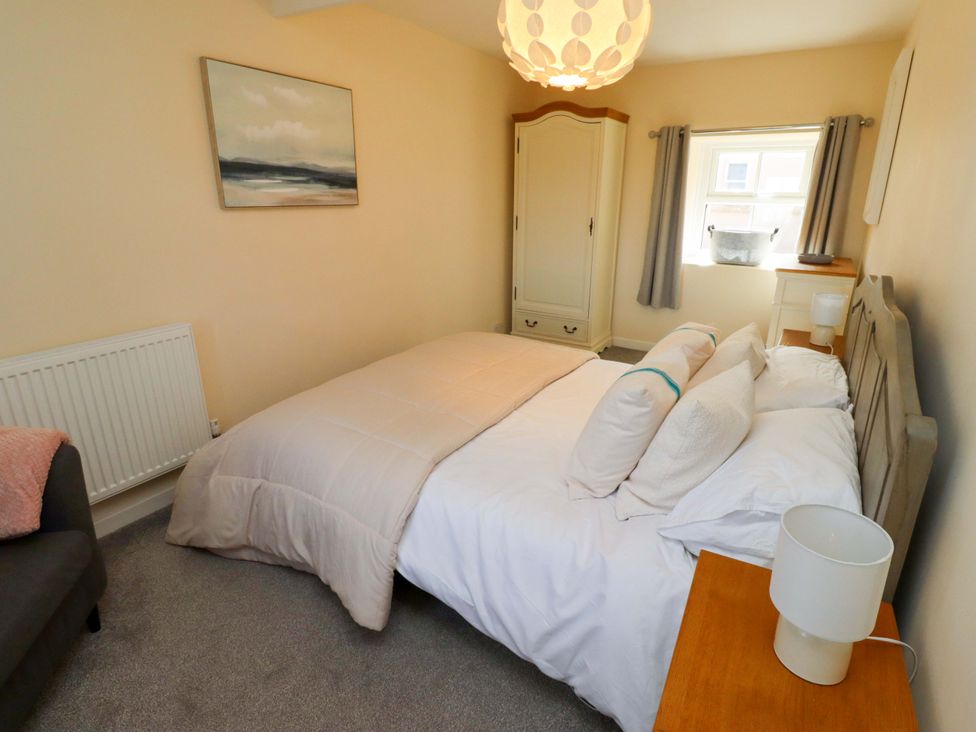 A bedroom with a bed and wardrobe at Barleycorn Cottage in Belford