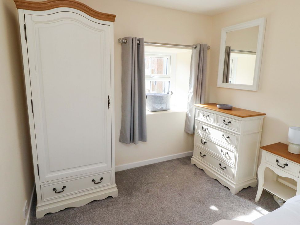 A bedroom with a wardrobe and chest of drawers at Barleycorn Cottage in Belford