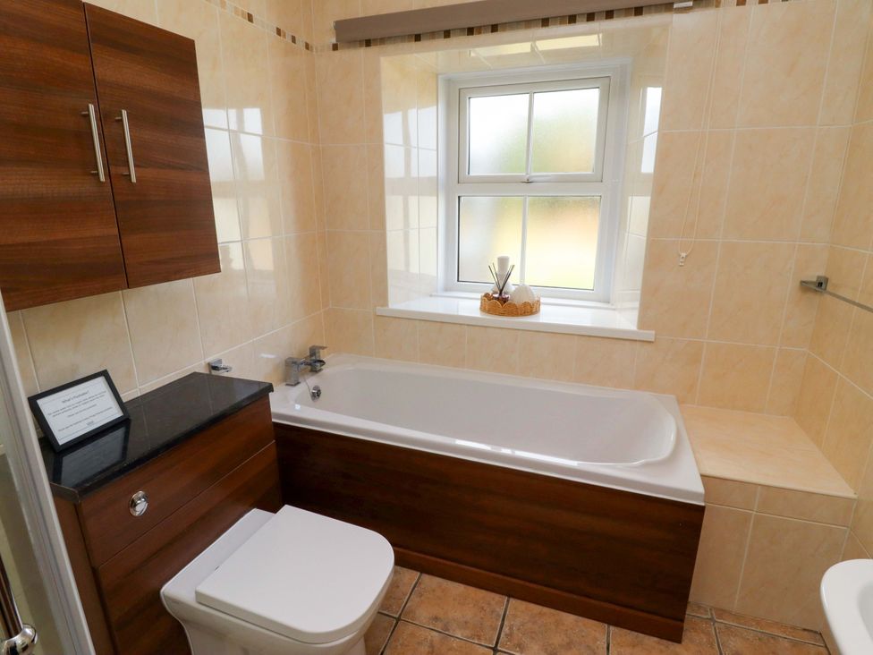 A bathroom with a bathtub and toilet at Barleycorn Cottage Belford