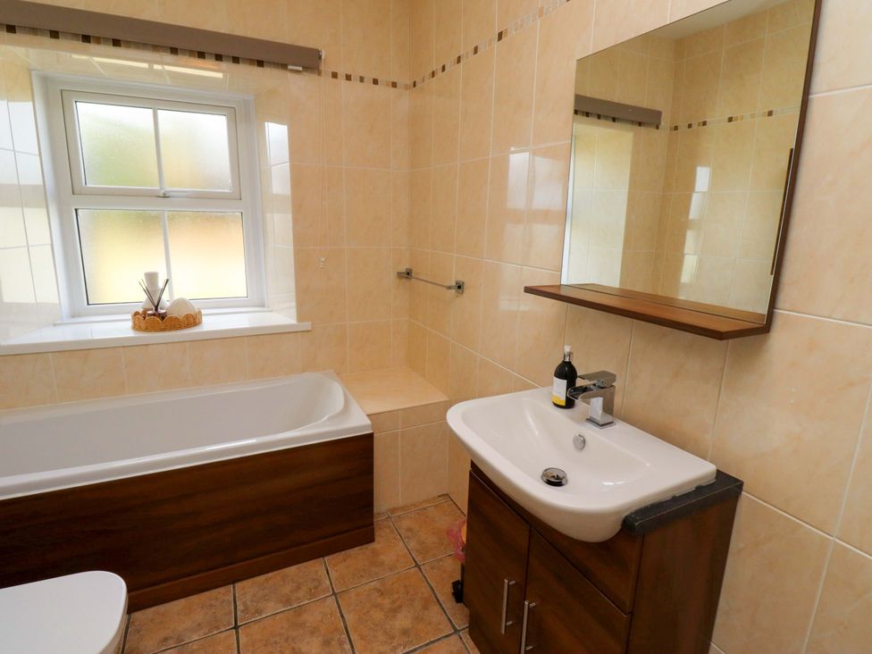 A bathroom with a sink and bath tub at Barleycorn Cottage in Belford