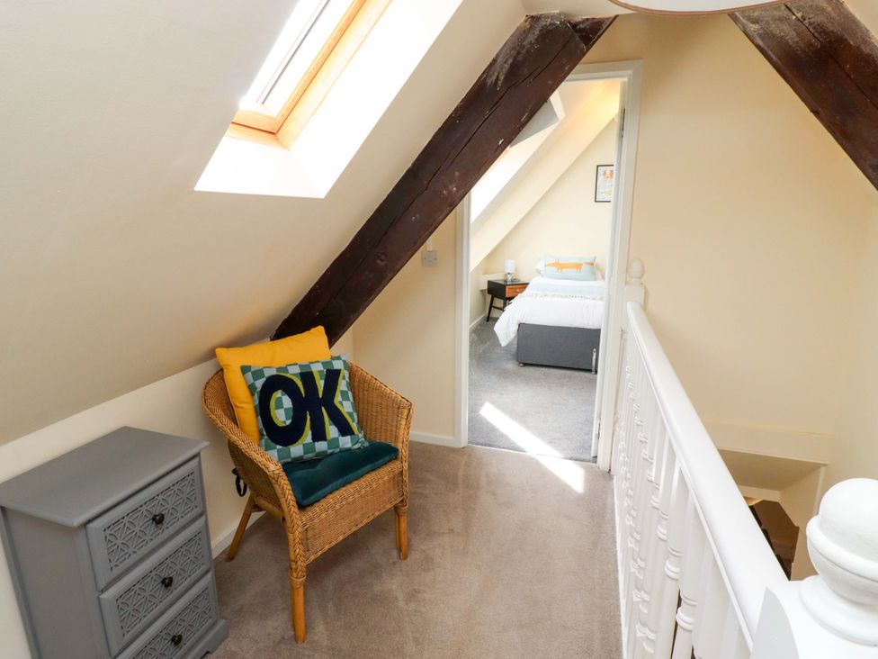 A landing area with a chair and furniture at Barleycorn Cottage in Belford