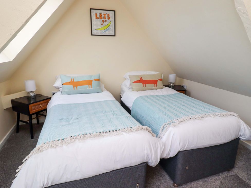 A bedroom with two single beds and a nightstand at Barleycorn Cottage in Belford