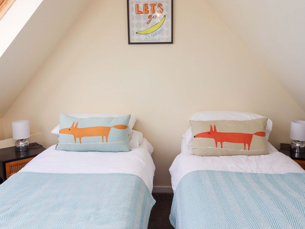 A bedroom with two beds and decorative pillows at Barleycorn Cottage in Belford
