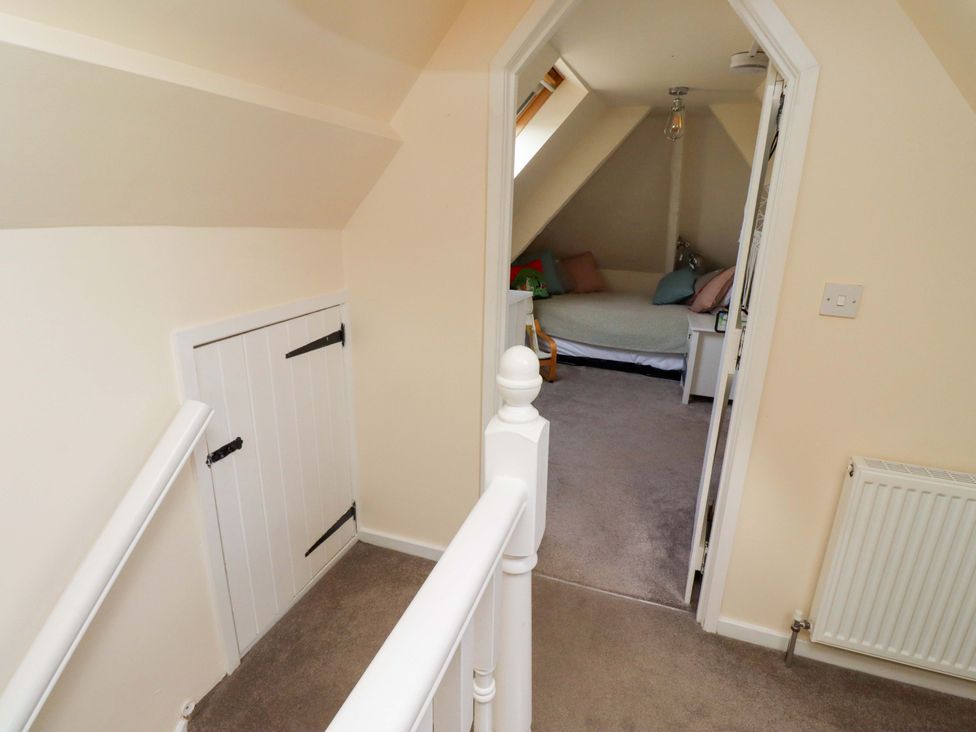 A landing area with a staircase and a door leading to a room at Barleycorn Cottage in Belford