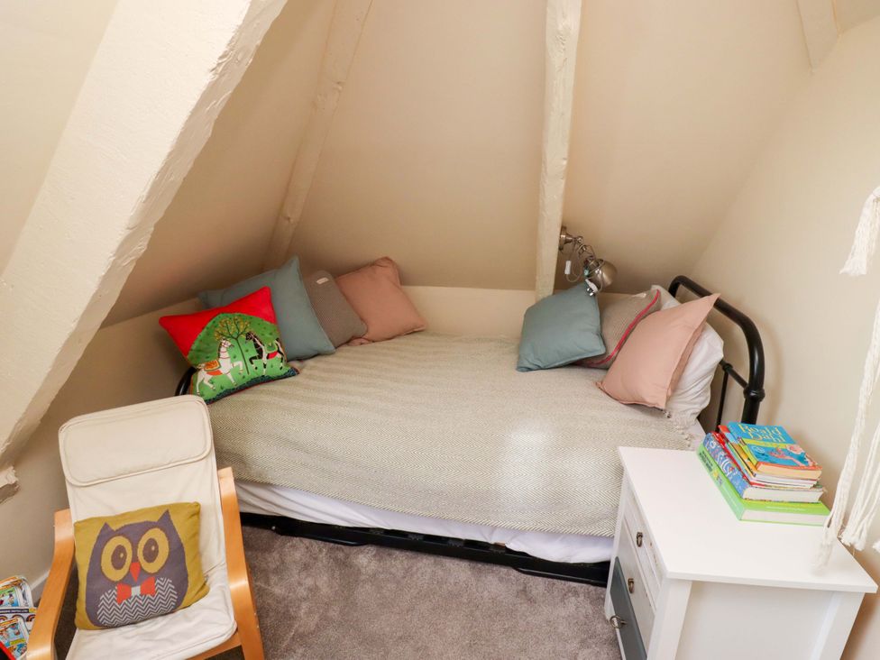A bedroom with a bed and side table at Barleycorn Cottage in Belford
