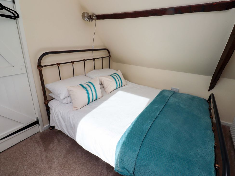 A bedroom with a bed and pillows at Barleycorn Cottage in Belford