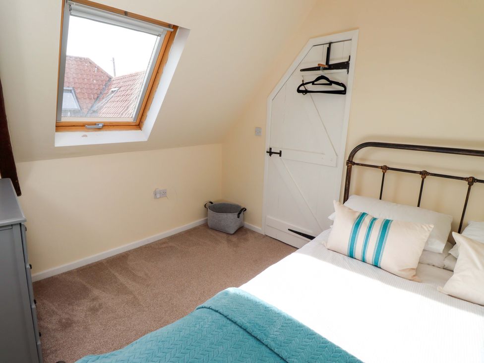 A bedroom with a bed and window at Barleycorn Cottage in Belford