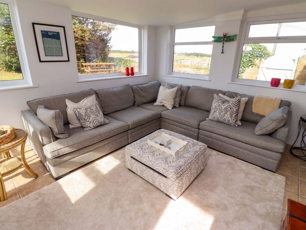 A living room with a sofa and coffee table at Barleycorn Cottage in Belford