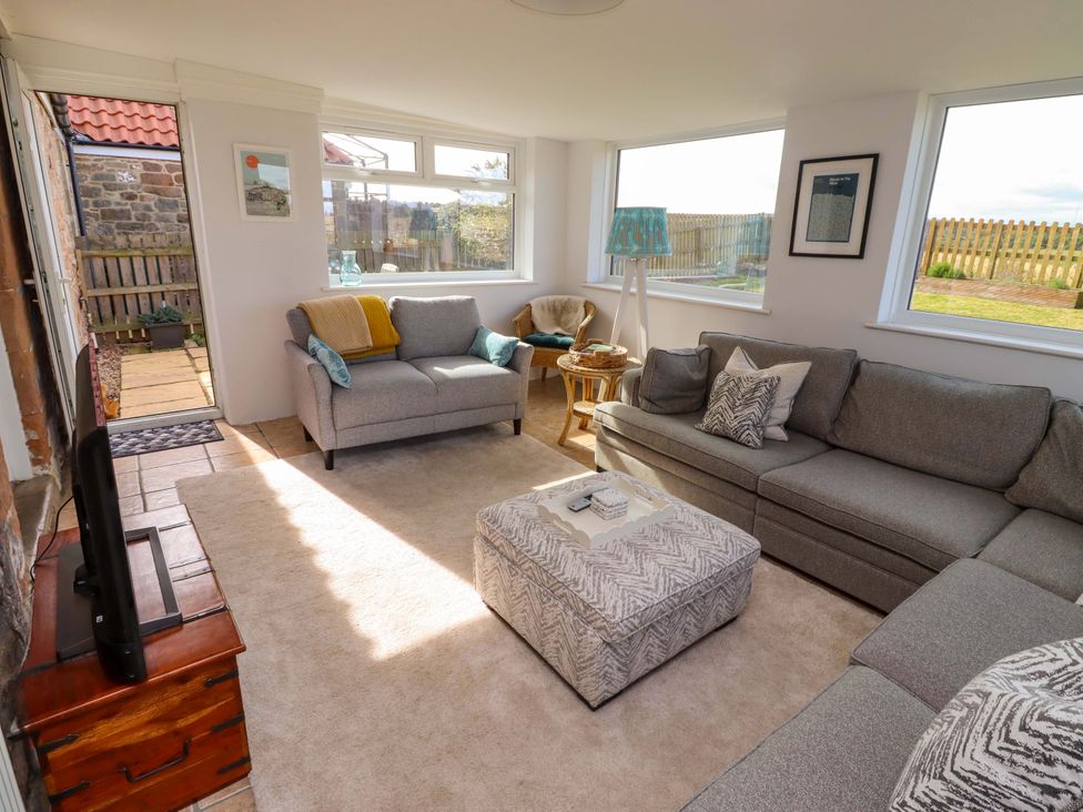 A living room with a sofa and coffee table at Barleycorn Cottage in Belford