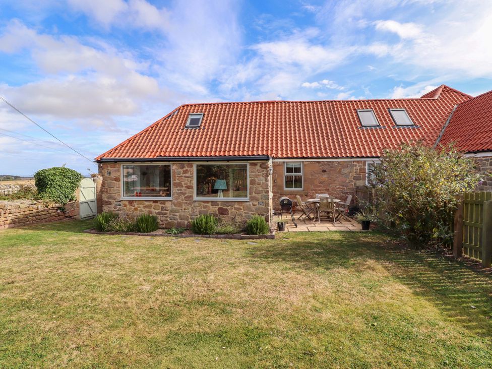A cottage with a garden and patio furniture at Barleycorn Cottage in Belford