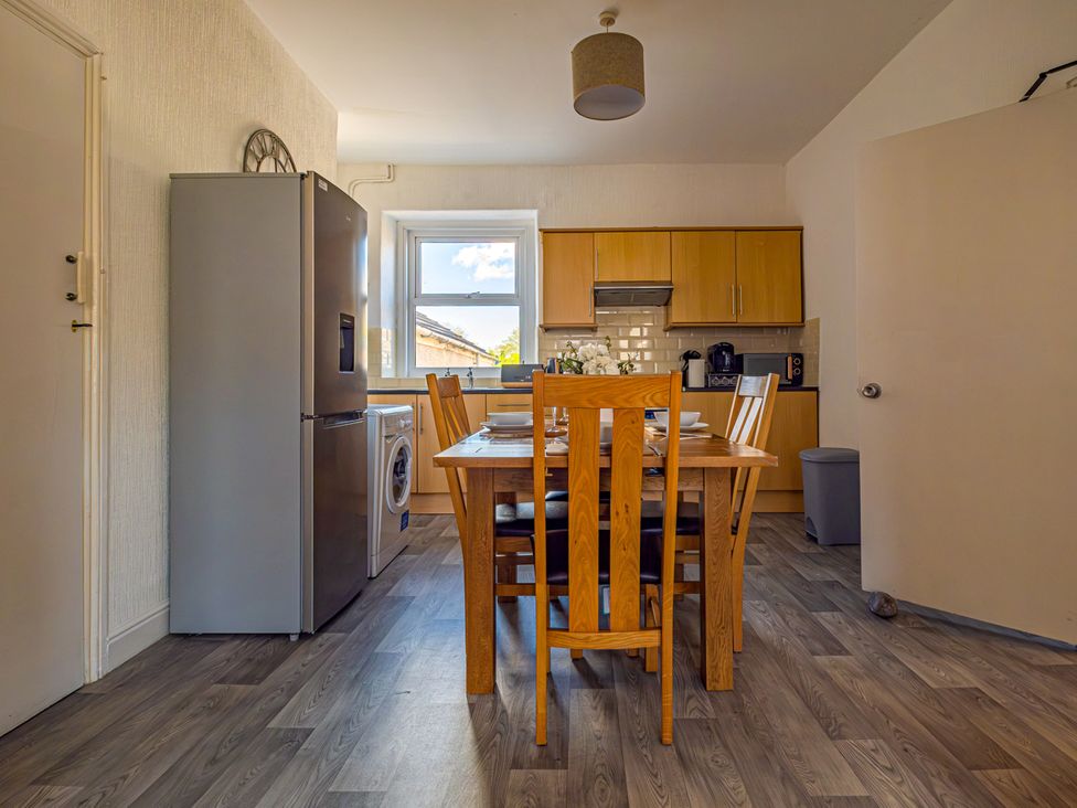 A kitchen with a dining table and appliances at Flat 56 Newton Road Abertawe
