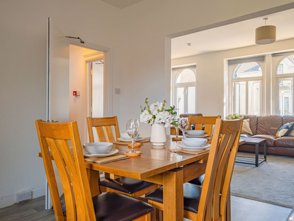 A dining room with a table set for meals at Flat 56 Newton Road Abertawe