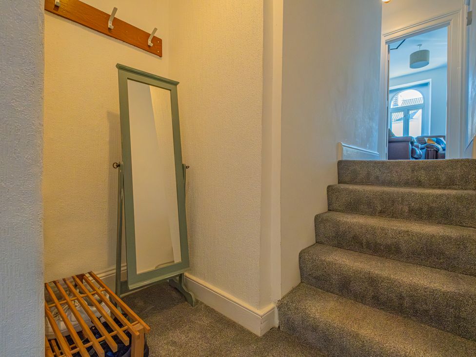 A hallway with a mirror and coat rack at Flat 56 Newton Road Abertawe