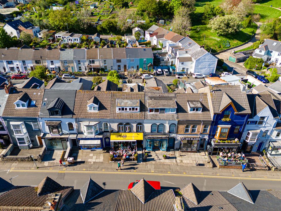 A street view showing shops and a garden area at Flat 56 Newton Road Abertawe