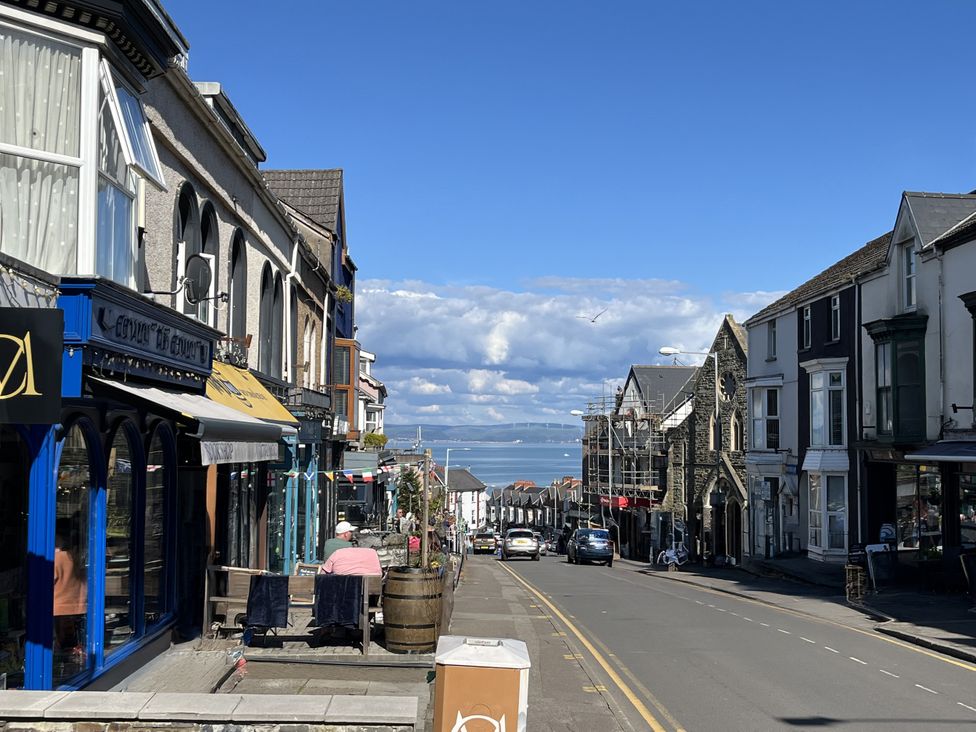 A street with shops and cars at Flat 56 Newton Road Abertawe