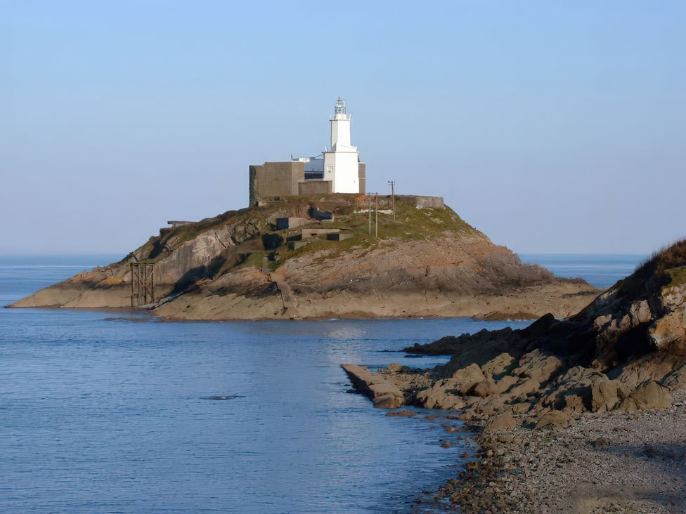 A lighthouse on a rocky island near the sea at Flat 56 Newton Road Abertawe
