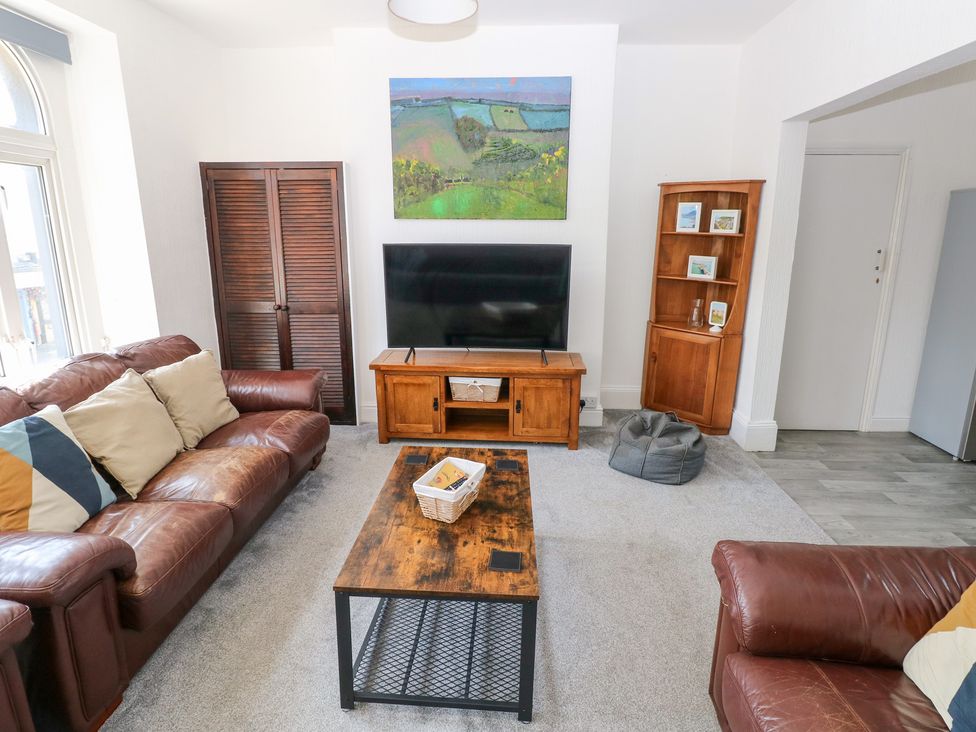 A living room with a television and coffee table at Flat 56 Newton Road in Mumbles