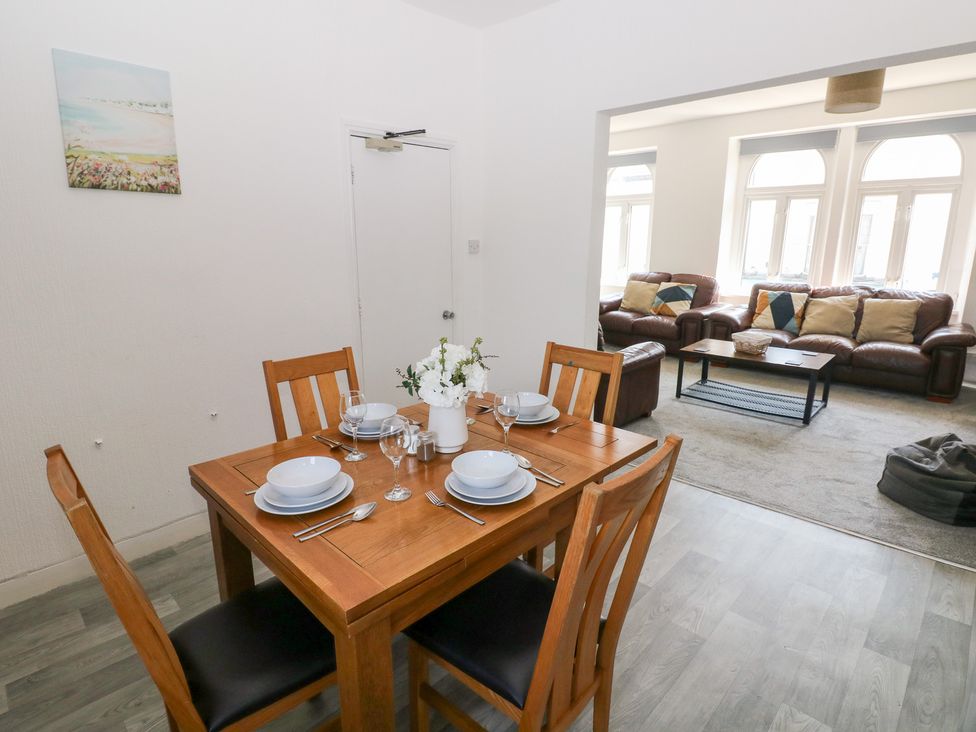 A dining room with a table set for dinner at Flat 56 Newton Road Mumbles