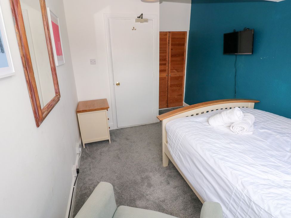 A bedroom with a bed and a TV at Flat 56 Newton Road in Mumbles