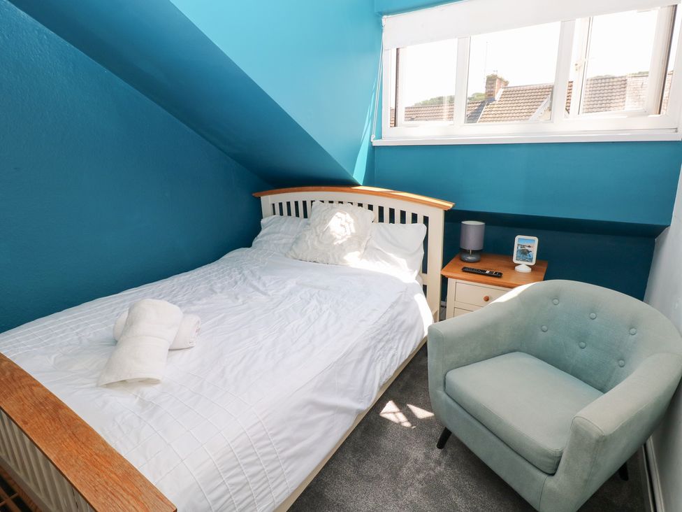 A bedroom with a bed and nightstand at Flat 56 Newton Road in Mumbles