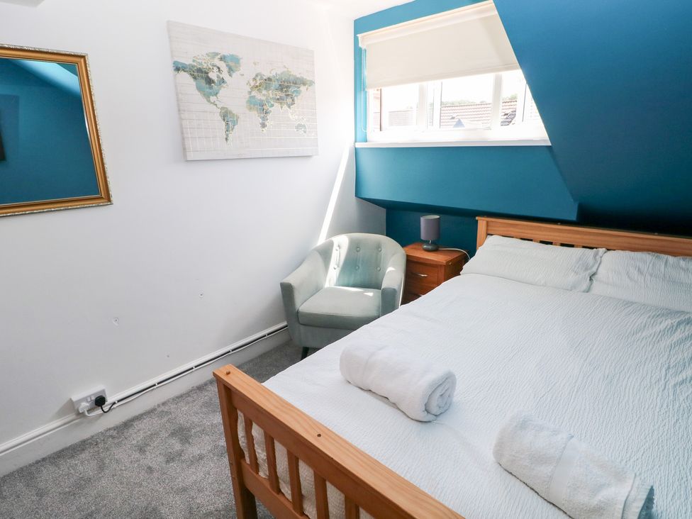 A bedroom with a bed and map on the wall at Flat 56 Newton Road Mumbles