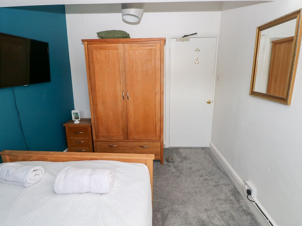 A bedroom with a bed and wardrobe at Flat 56 Newton Road Mumbles