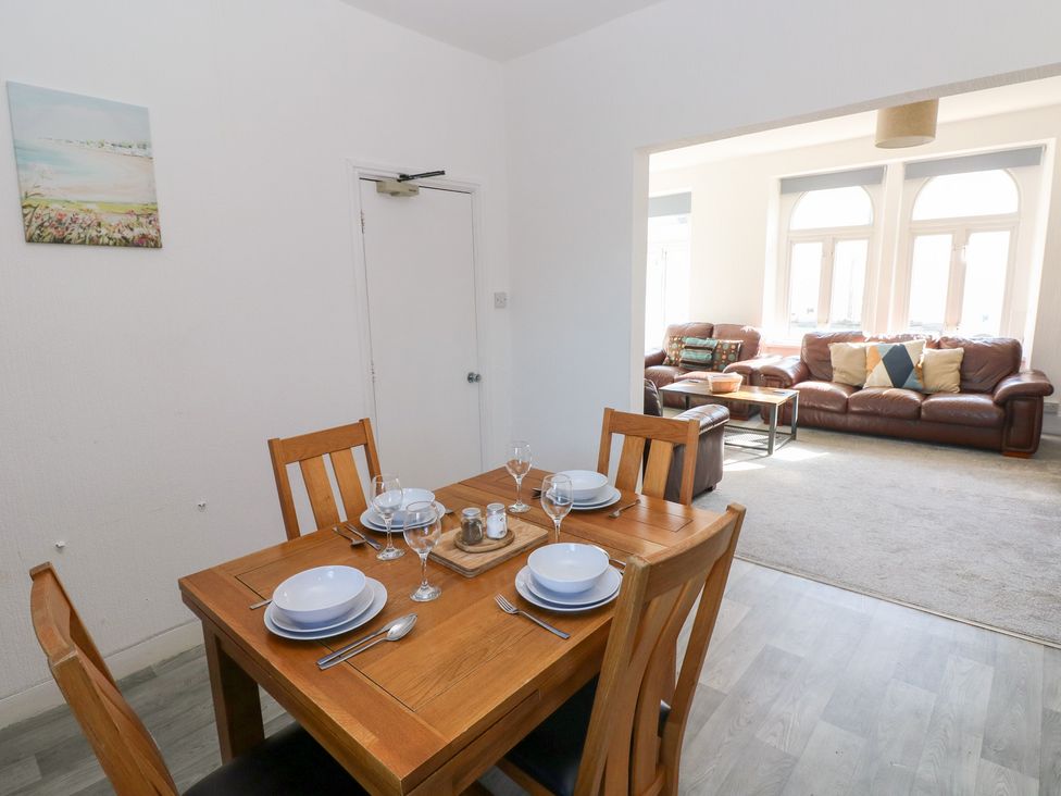 A dining room with a table set for a meal at Castleview Coastal Comfort in Mumbles