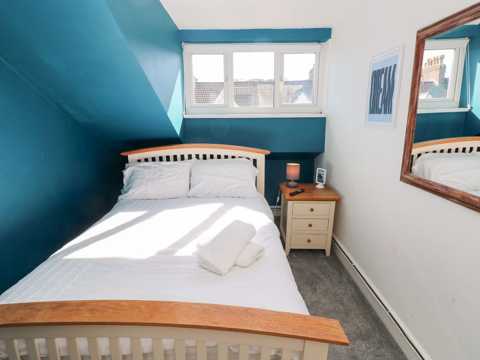 A bedroom with a bed and nightstand at Castleview Coastal Comfort in Mumbles