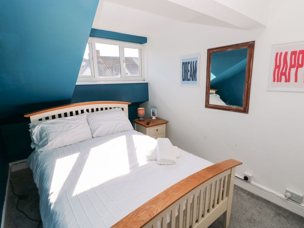 A bedroom with a bed and nightstand at Castleview Coastal Comfort in Mumbles