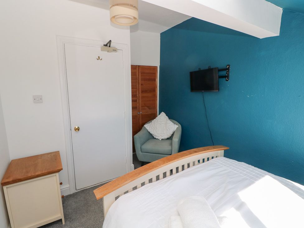 A bedroom with a bed and a television at Castleview Coastal Comfort in Mumbles