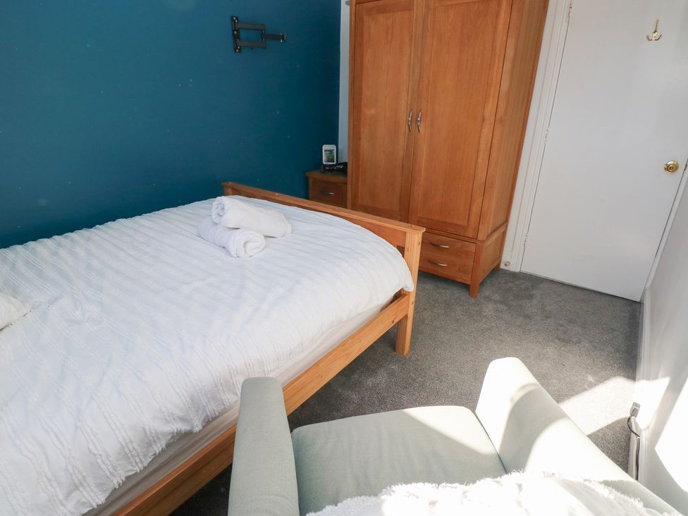 A bedroom with a bed and wardrobe at Castleview Coastal Comfort in Mumbles