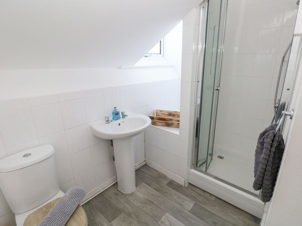 A bathroom with a shower, sink, and toilet at Castleview Coastal Comfort in Mumbles