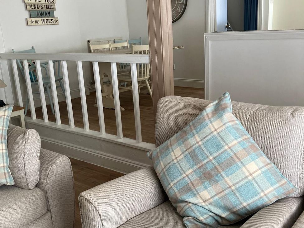 A living room featuring a sofa and chairs with a table visible at Claire Cottage