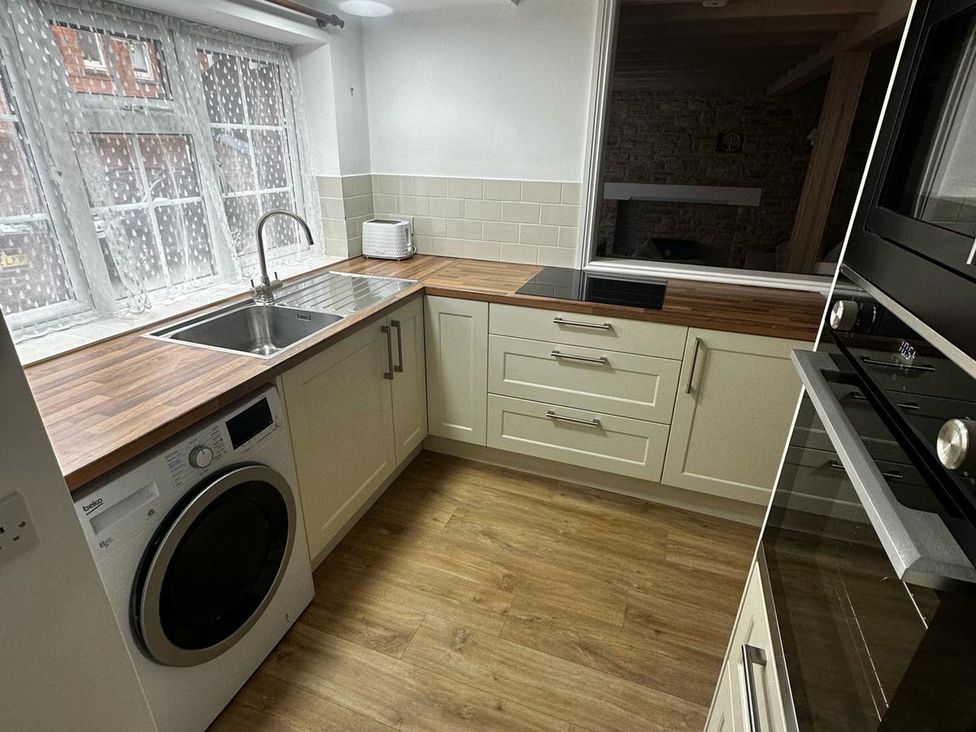 A kitchen with a sink and washing machine at Claire Cottage