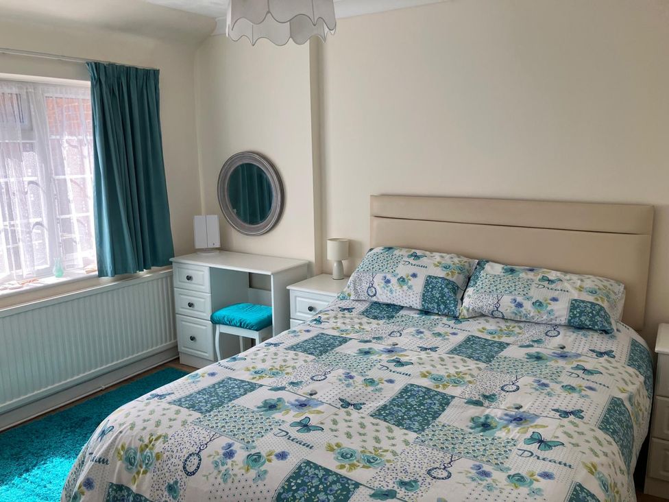 A bedroom with a bed and a dressing table at Claire Cottage