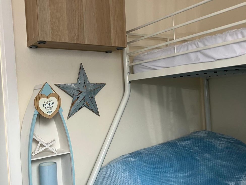 A bedroom with a bunk bed and decorative items at Claire Cottage