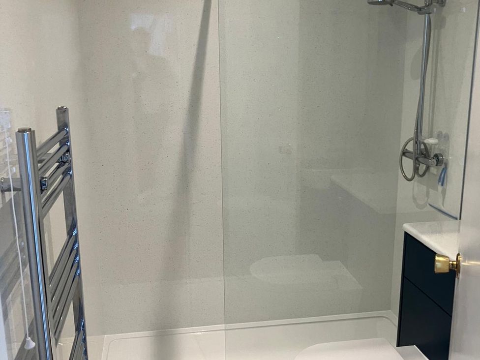 A bathroom with a shower and towel rail at Claire Cottage