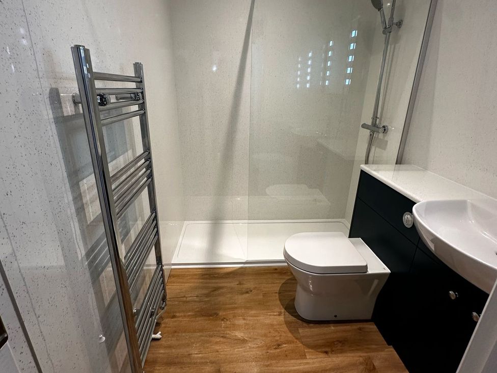 A bathroom with a shower, toilet, and sink at Claire Cottage