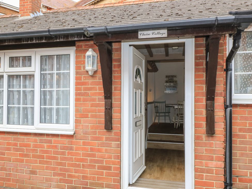 An entrance with a door and window at Claire Cottage in Swanage