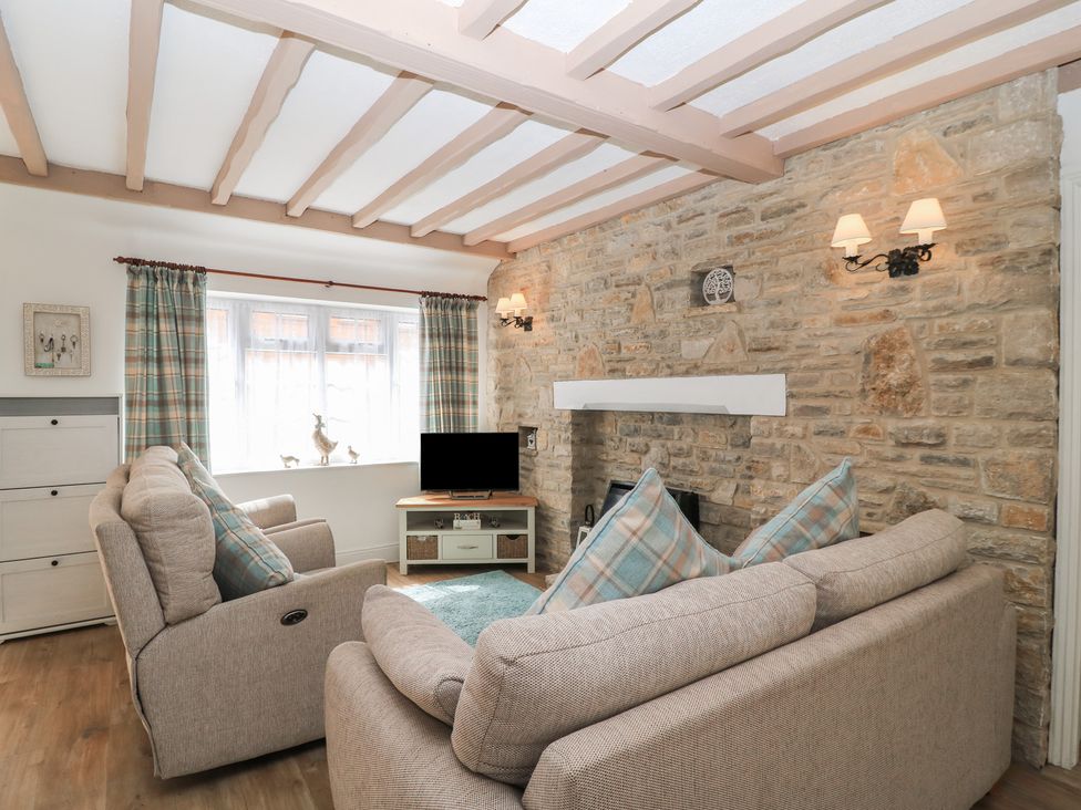 A living room with a sofa and television at Claire Cottage in Swanage