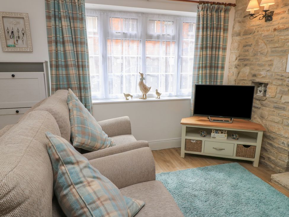 A living room with a sofa and television at Claire Cottage in Swanage