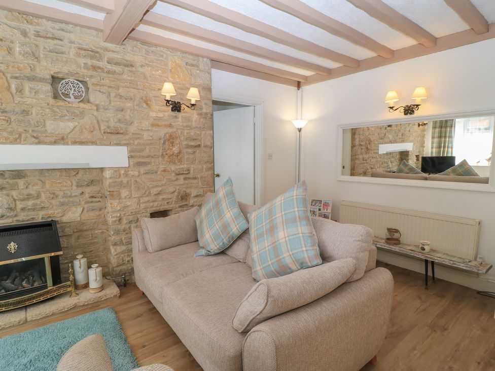A living room with a sofa and fireplace at Claire Cottage in Swanage